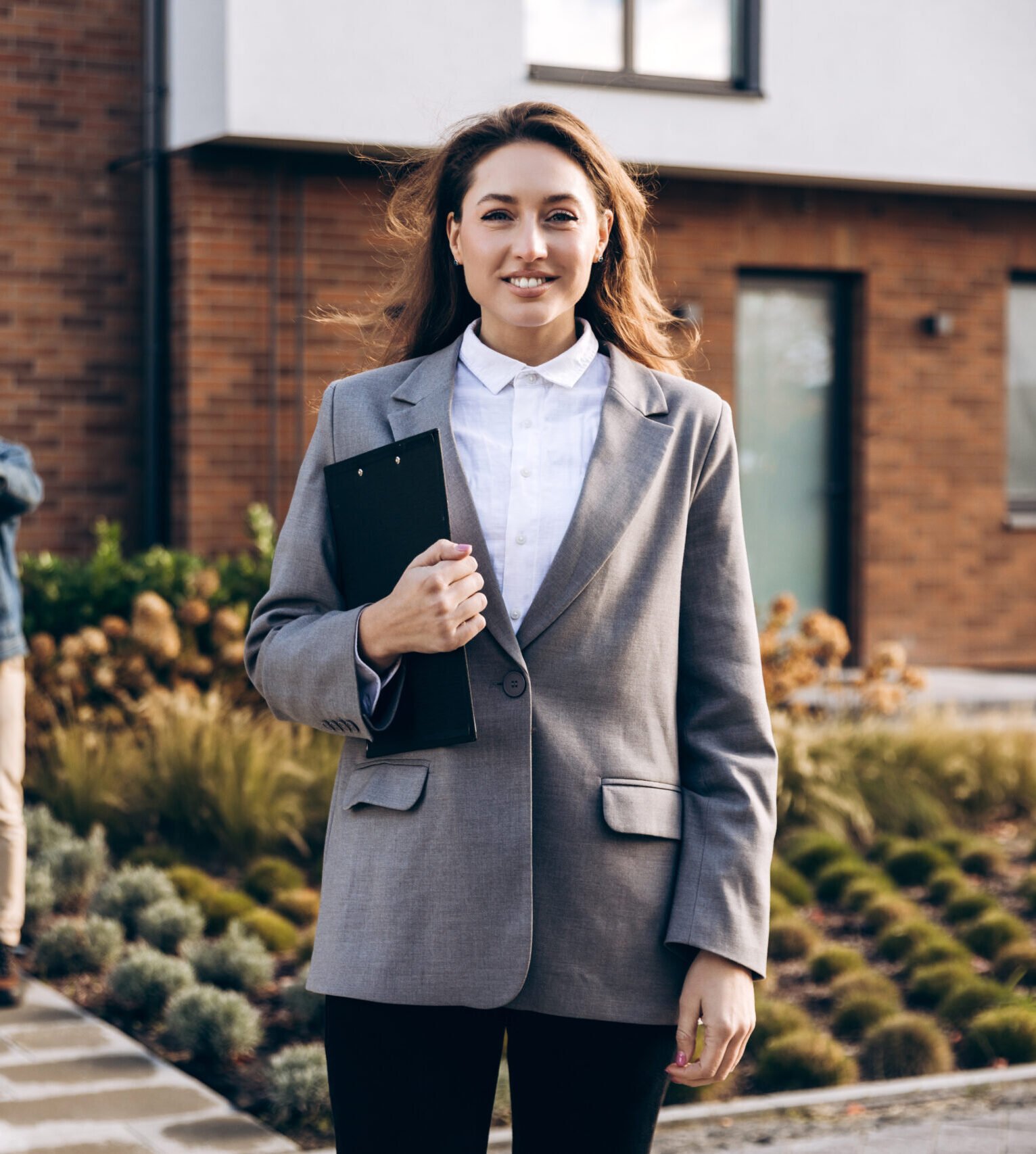 beautiful-woman-real-estate-agent-smiling-while-c-2026-01-11-11-02-13-utc-scaled-e1777377027592 